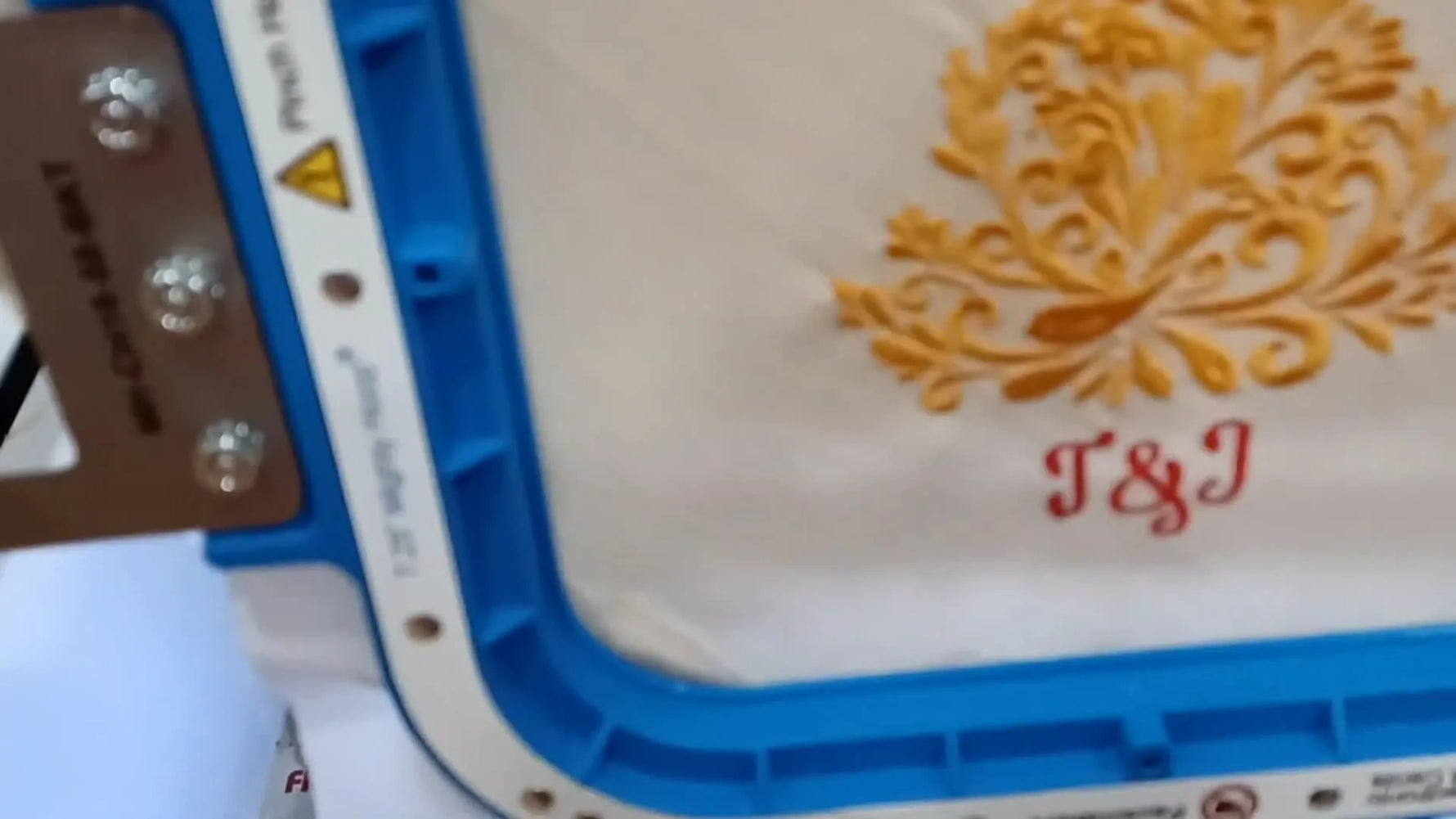 A finished two-color holiday napkin design sits cleanly stitched inside a magnetic hoop on a Ricoma multi-needle machine.