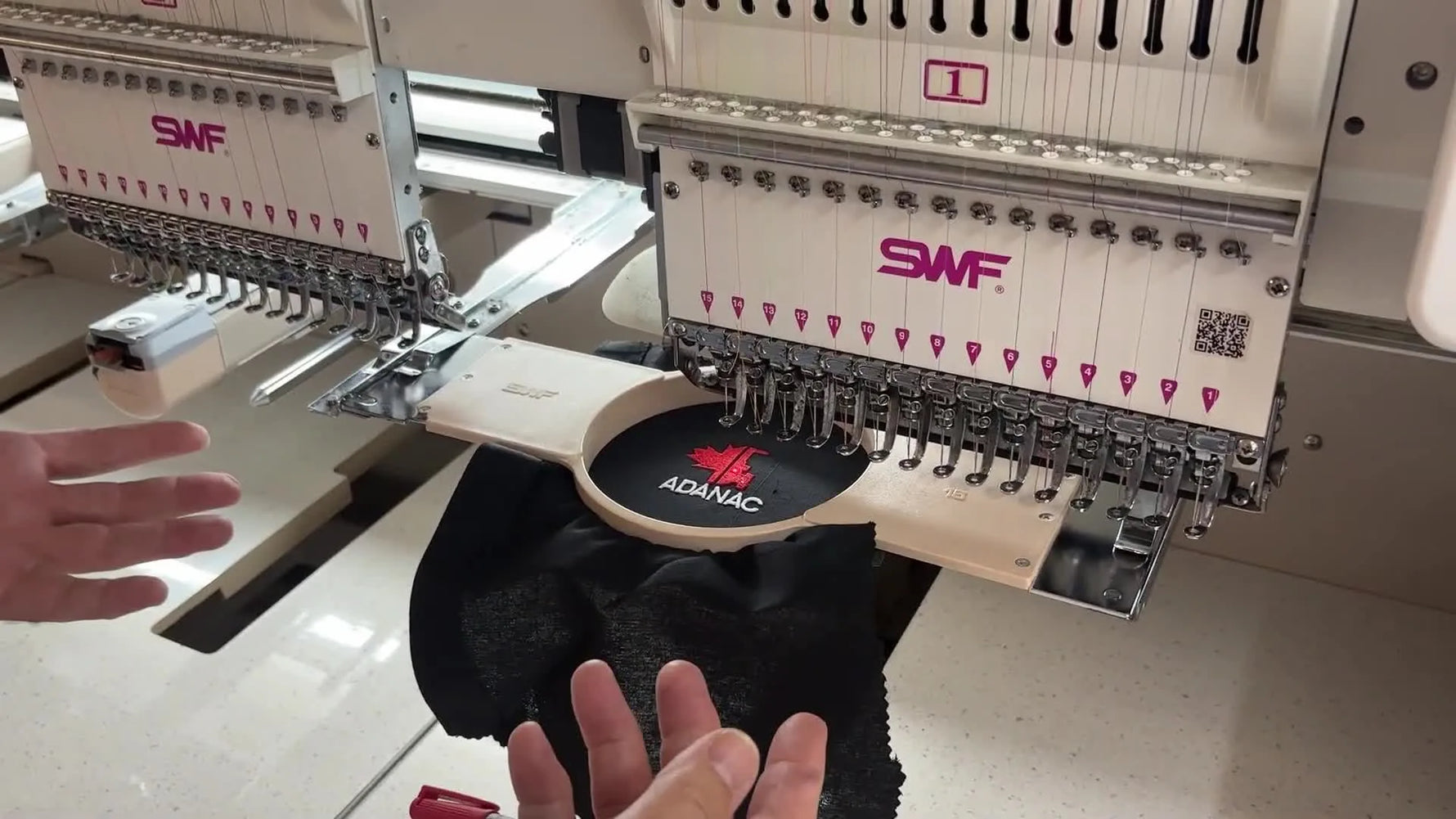 A close-up of the operator lifting the magnetic top frame off a finished piece, showing the fast “on/off” changeover that drives commercial throughput.