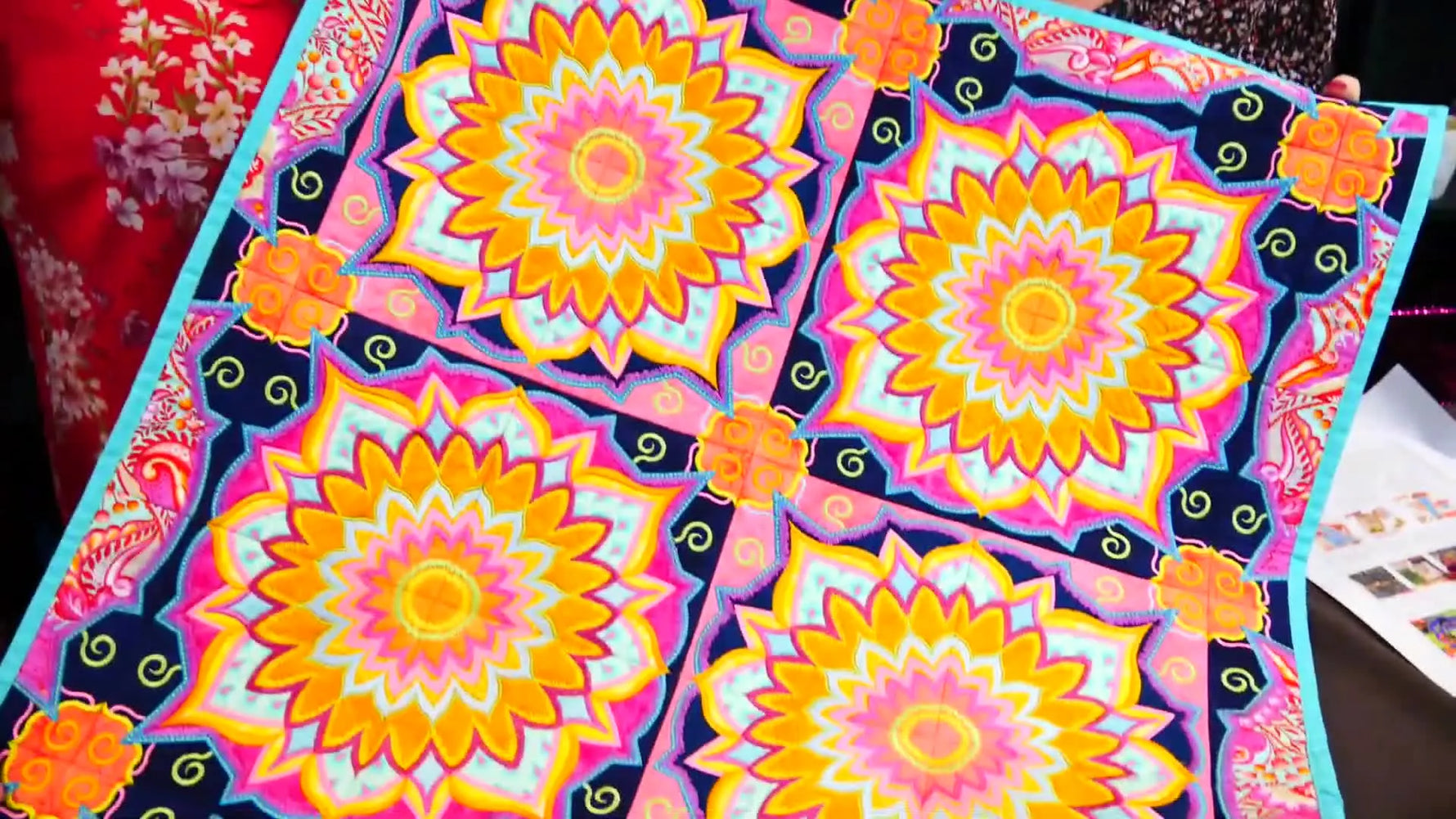 An overhead view of the Ornamental Round Quilt with a vibrant mandala-style embroidery layout that highlights texture and stitch-direction changes.