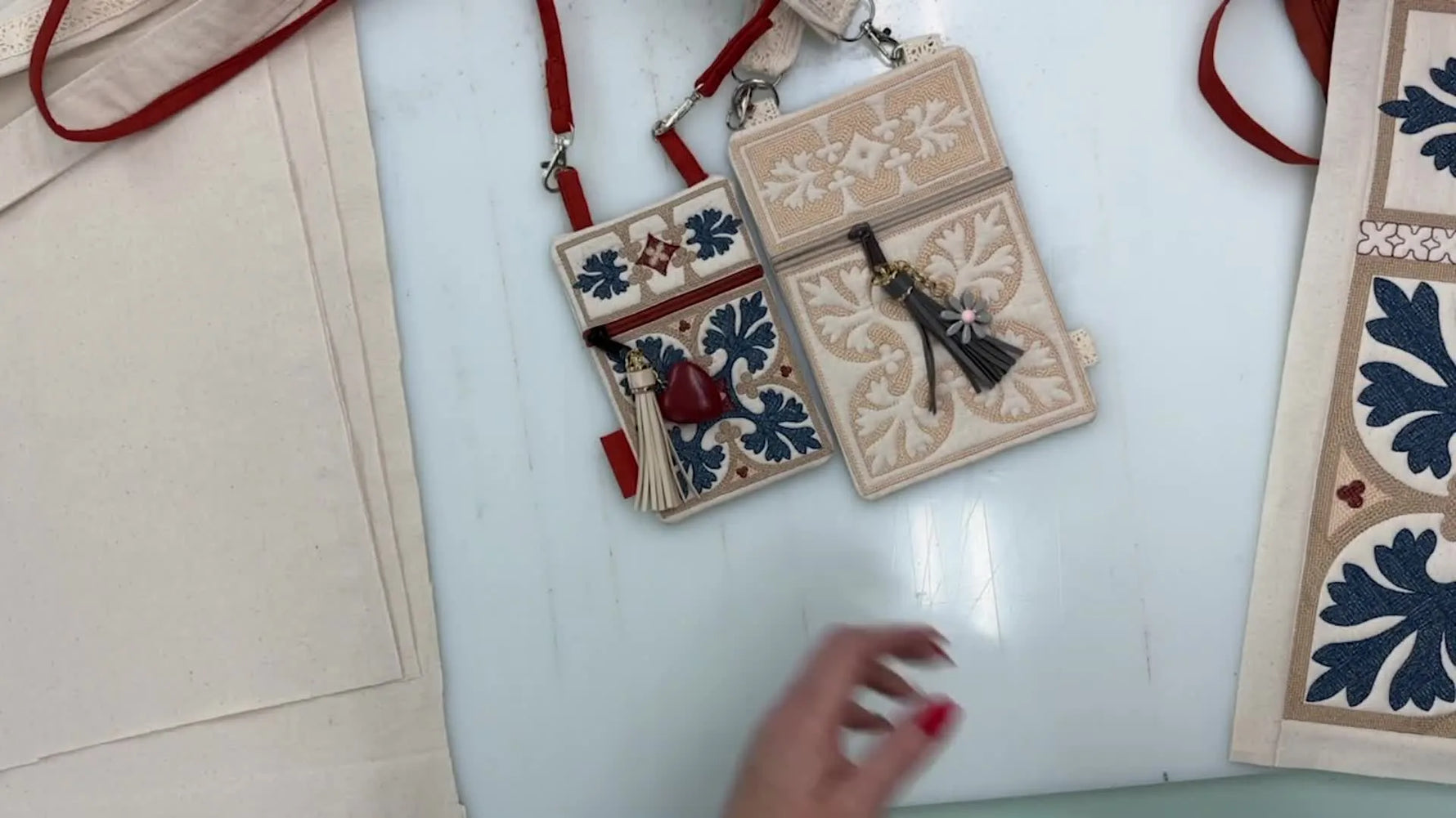 Close-up of finished in-the-hoop zipper pouches with tassels and D-ring straps.