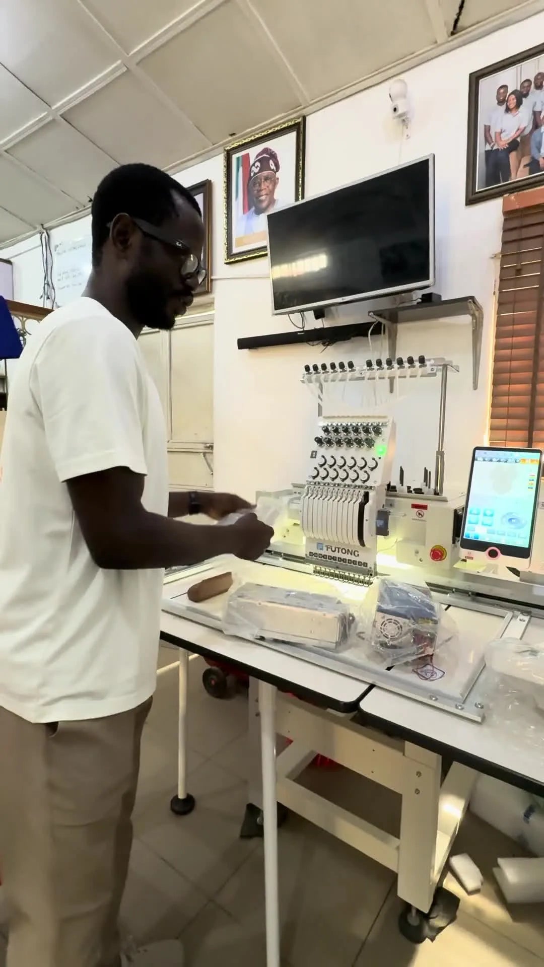 The presenter holds the Dahao A15 Pro screen unit and the matching control box together to show the full upgraded system on the Futong machine.