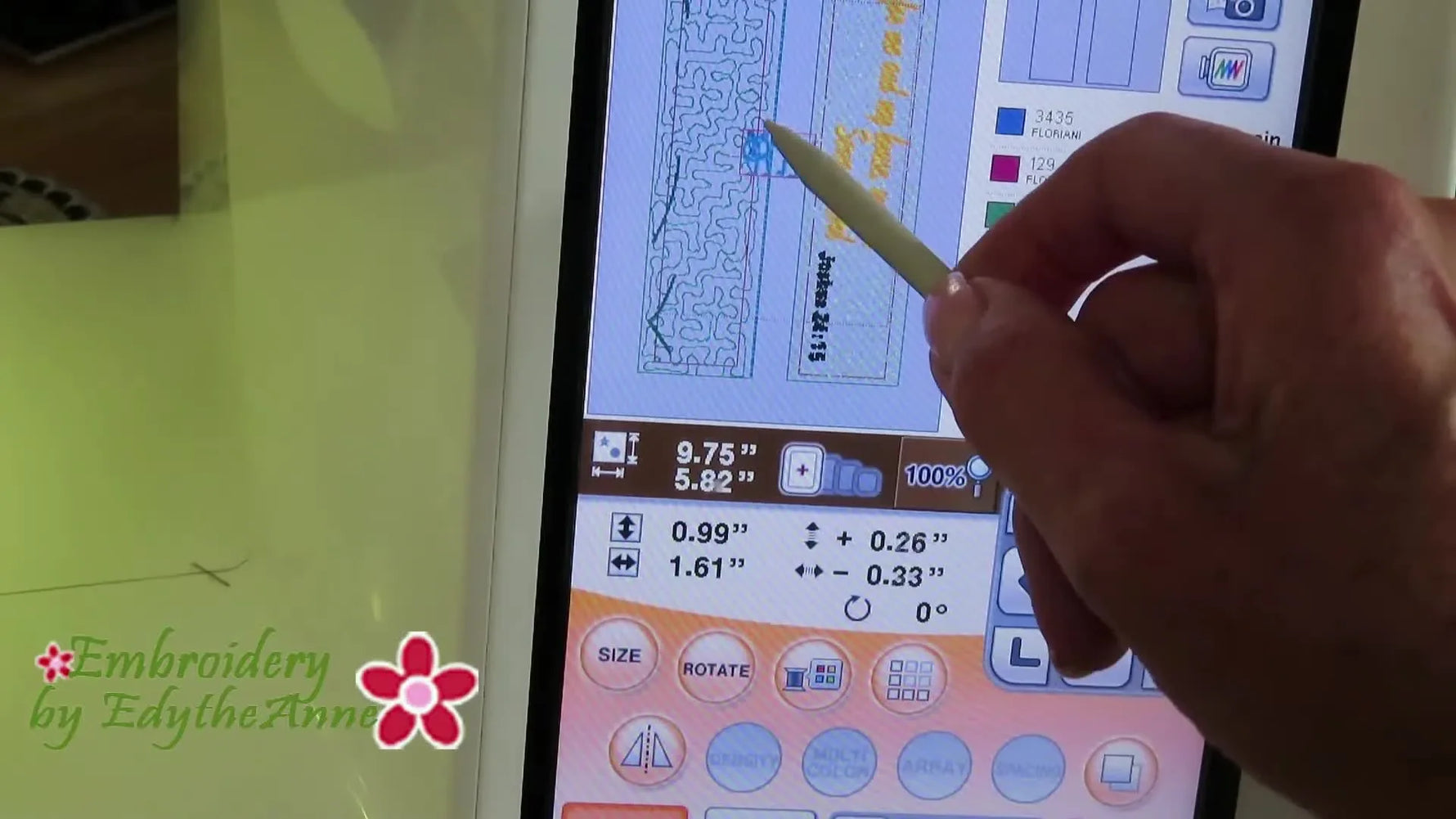 A stylus drags a highlighted cat design across the Baby Lock embroidery machine screen to position it on a panel layout.