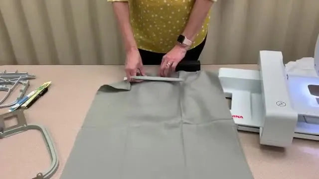 Hands press the inner hoop into the outer hoop with fabric and stabilizer aligned for a clean, straight hooping result.