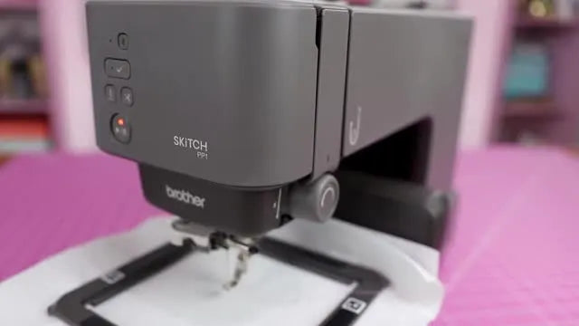 Close-up of the Brother Skitch PP1 embroidery machine on a cutting mat, emphasizing its minimal on-machine controls and app-dependent workflow.