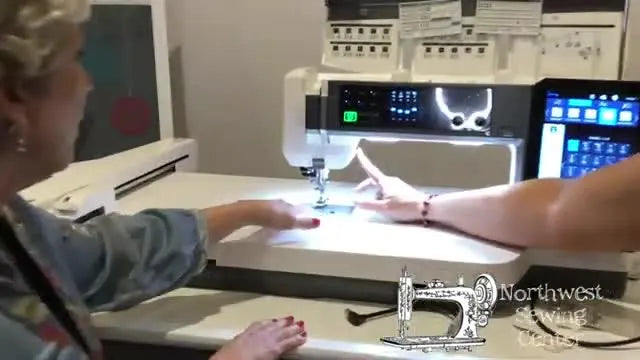 A close-up shows the Janome Continental M17 thumbwheel being turned for precise needle positioning under bright LED lighting.