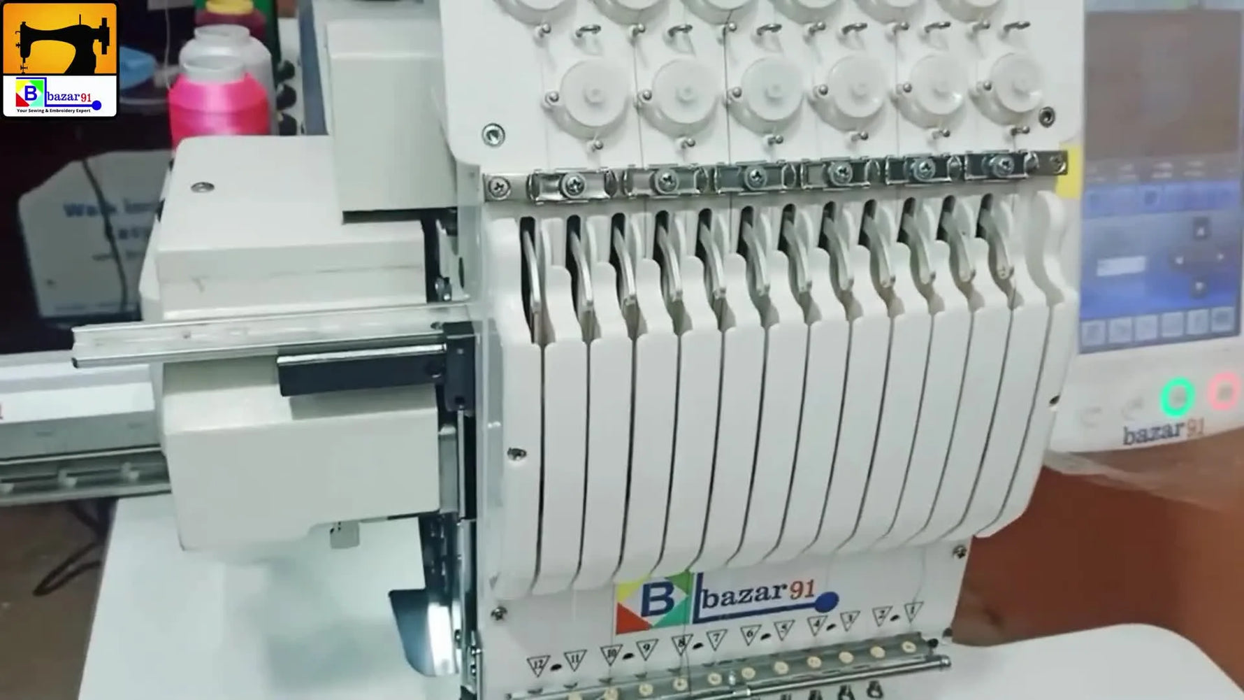Full view of the multi-needle embroidery machine with thread cones and control panel.