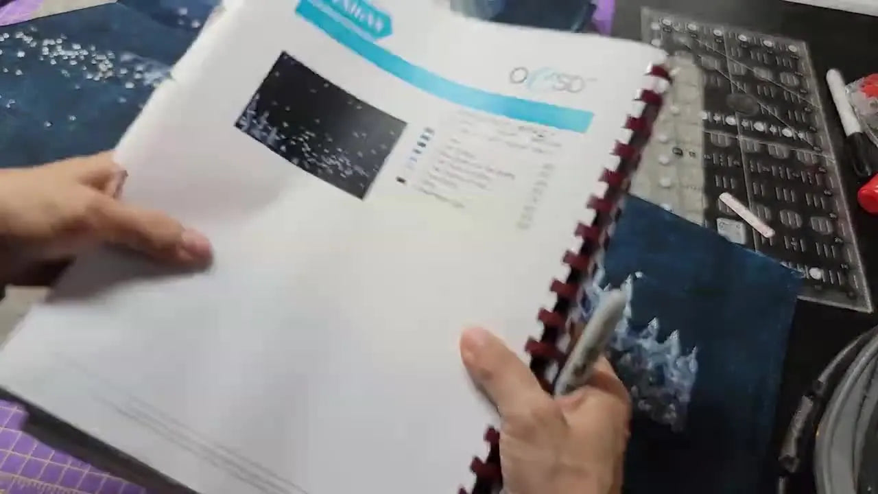 A close-up shows a rotary cutter trimming an embroidery tile precisely along a ruler edge for a clean, consistent seam allowance.