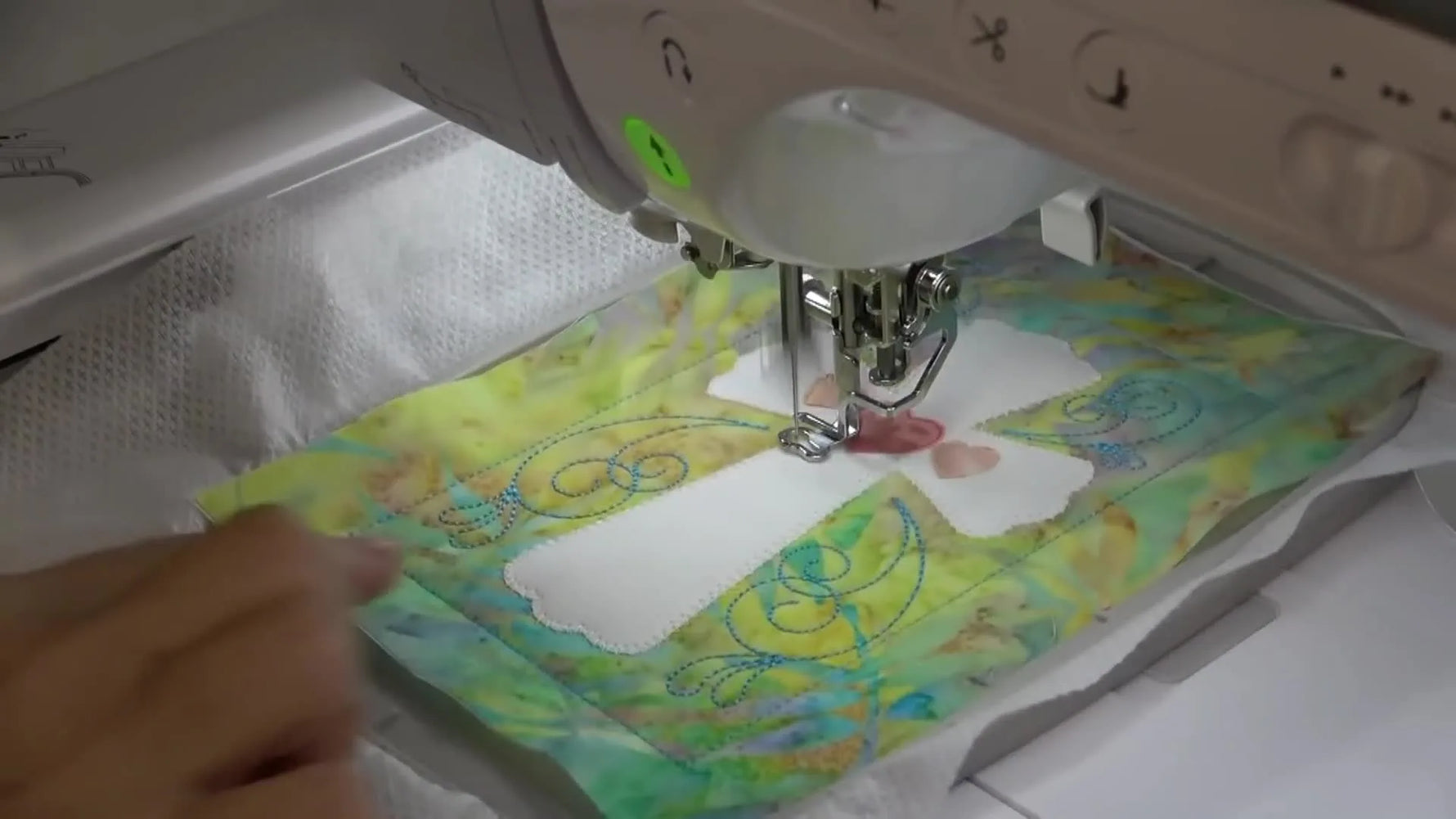A close-up of the Brother Luminaire stitching the final satin outline around the cross appliqué.