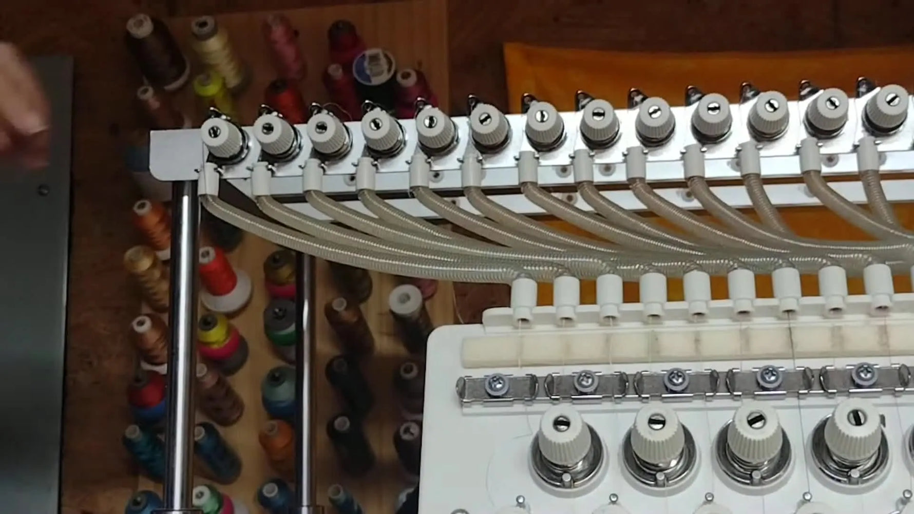 Hand wrapping thread around the upper tension disc on the left side, between the two discs.