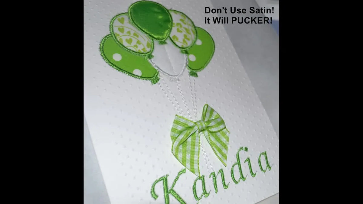 Completed embroidered card displayed outdoors.