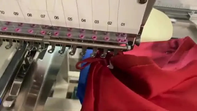 Close-up of active stitching on a Christmas stocking while the operator holds excess fabric safely away from the needle.