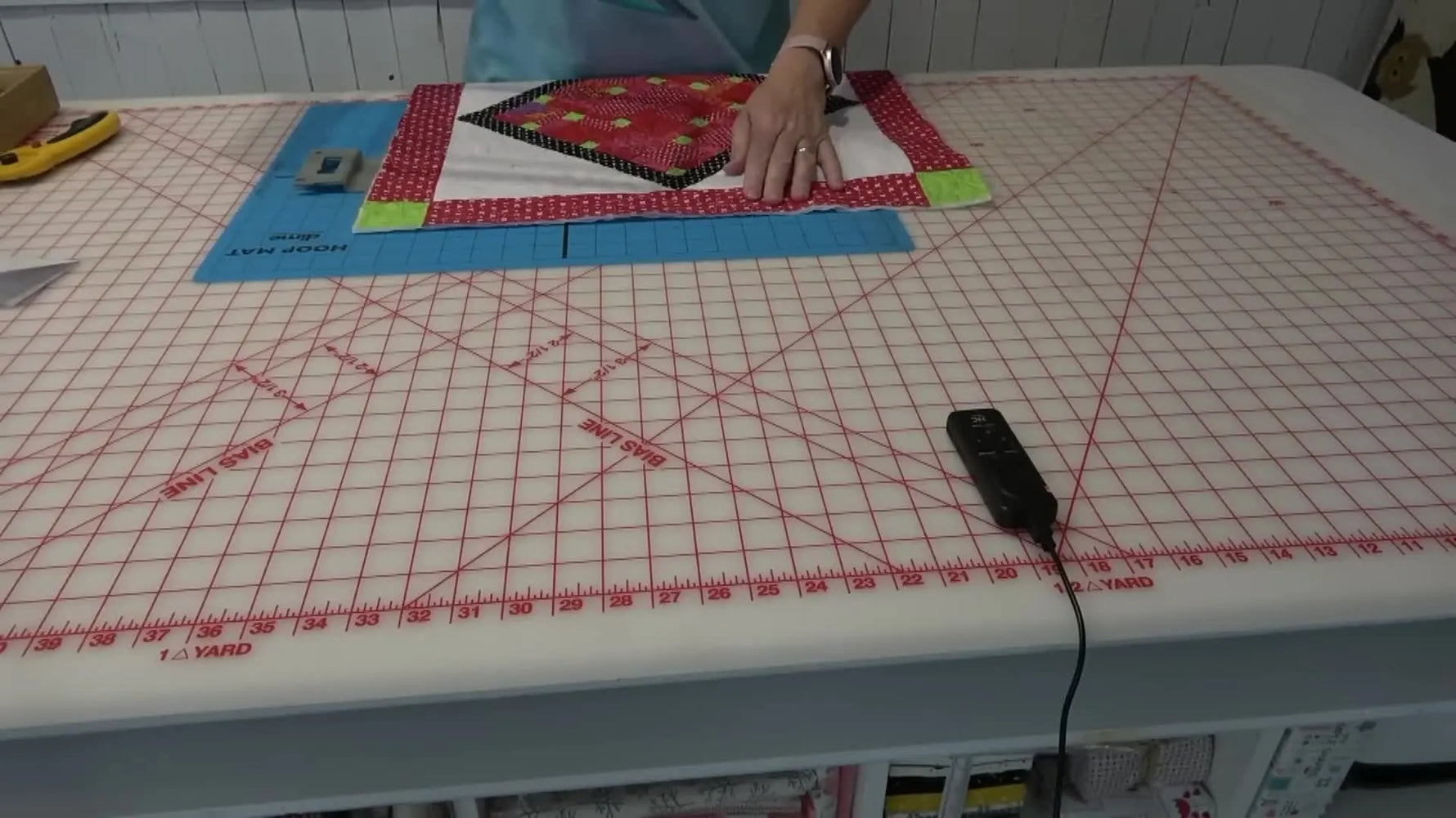 A magnetic hoop snaps down over a thick quilted table topper sandwich, showing how bulky projects can be hooped quickly and evenly.