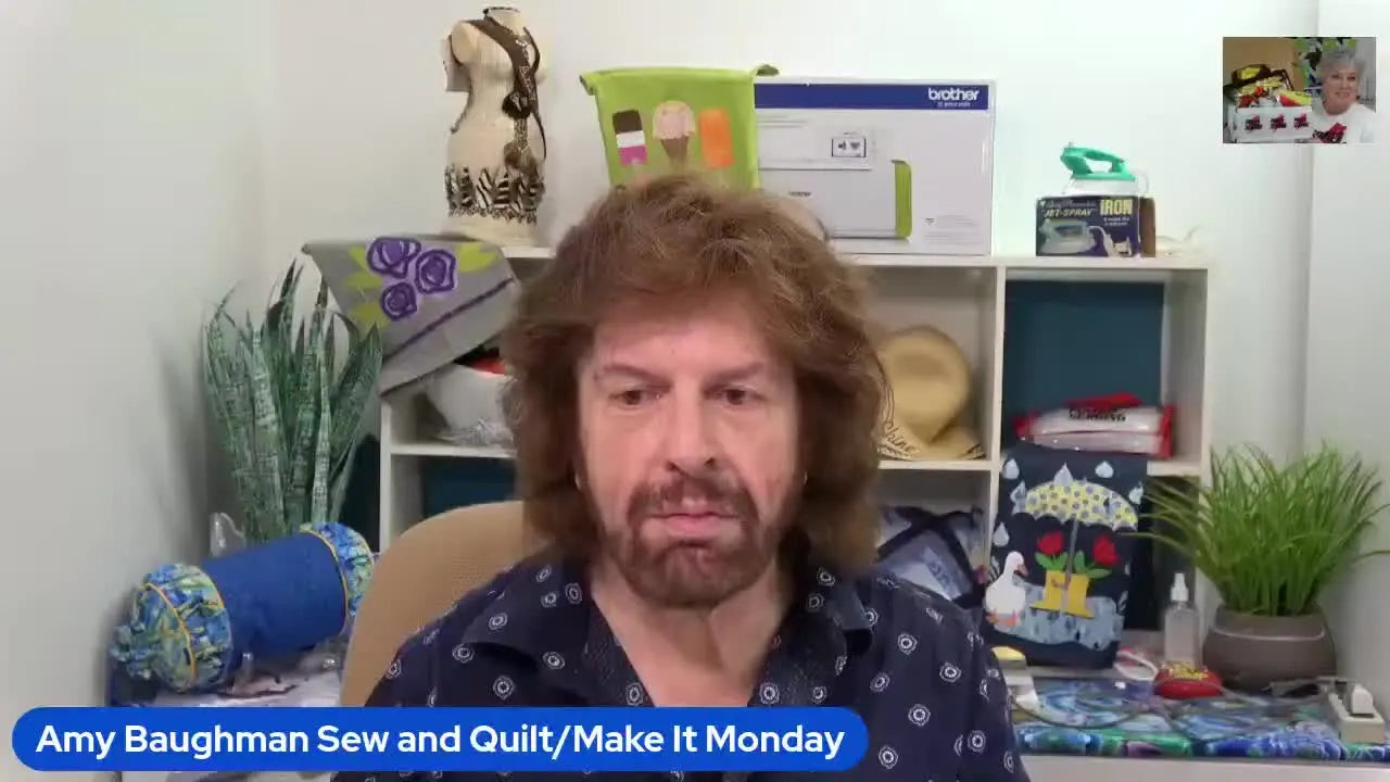 Man talking to camera with embroidery machine in background