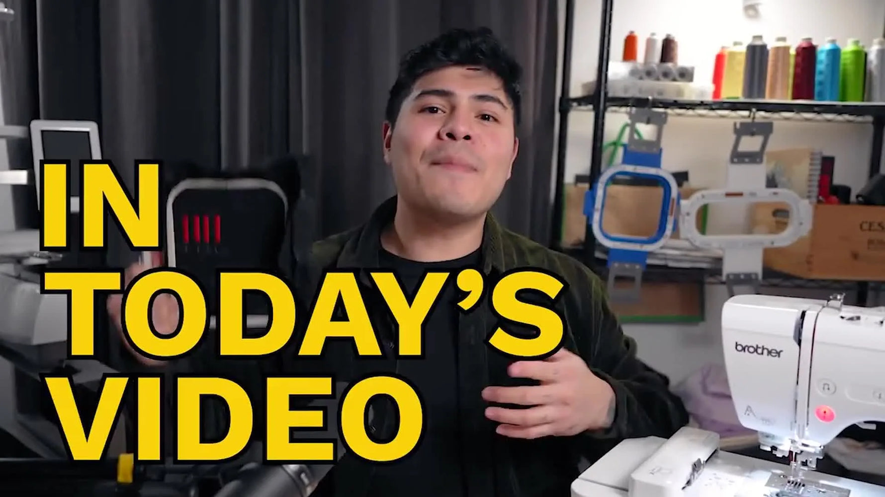 Man holding a black hooped fabric with red and white embroidery, demonstrating a finished tension test.