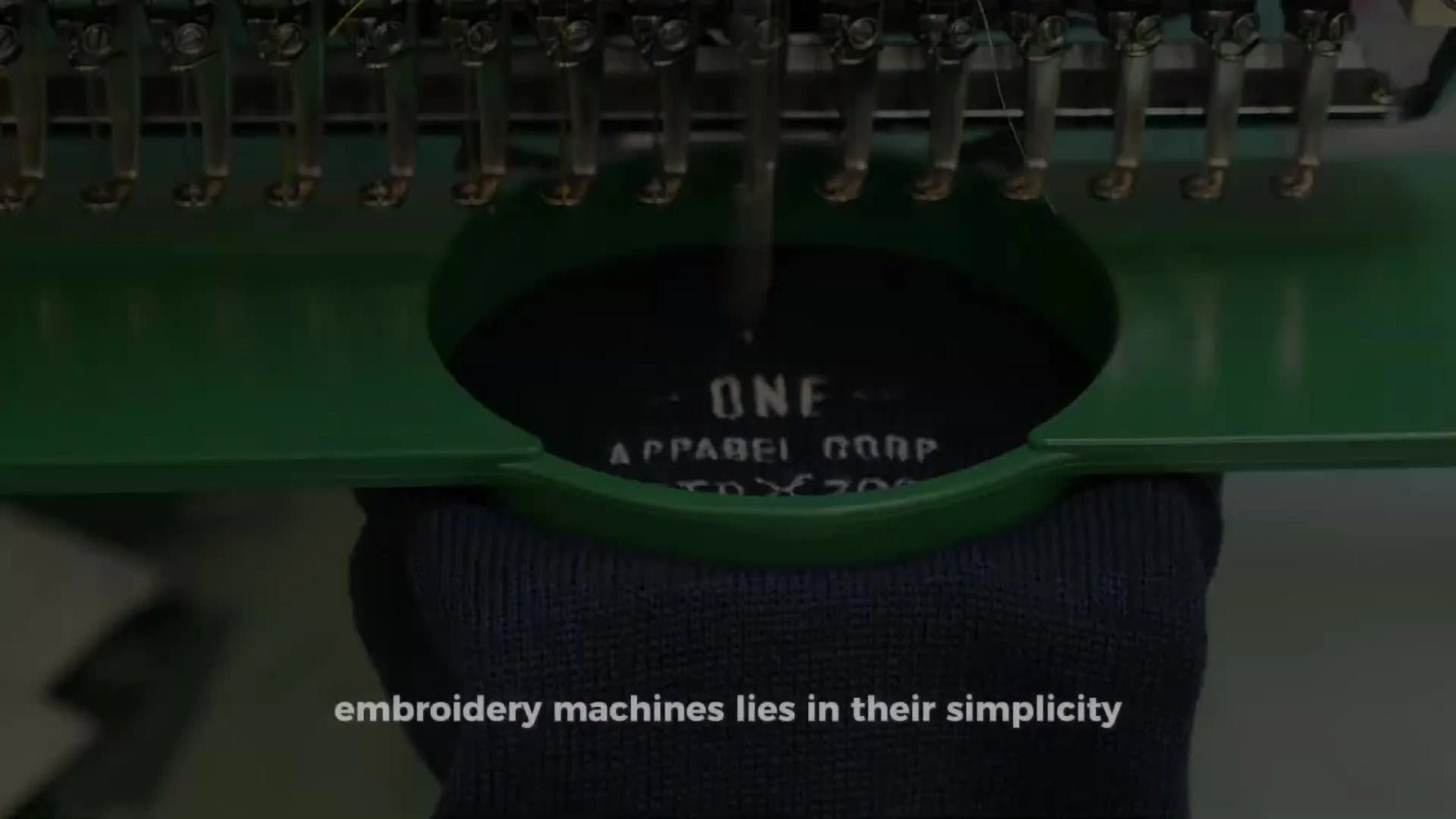 A close-up of a single-head machine stitching a crisp “MOUNTAIN EXPEDITION” logo on black felt, showing the kind of clean results beginners can achieve with the right setup.
