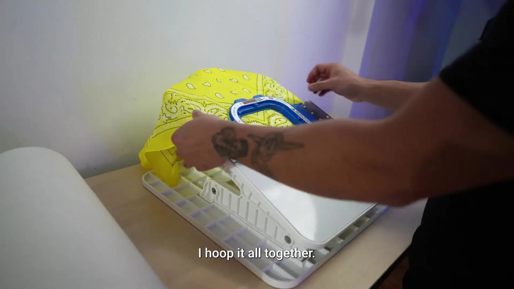 A magnetic hoop snaps shut over a folded yellow bandana on a hooping station, instantly locking the fabric and stabilizer flat.
