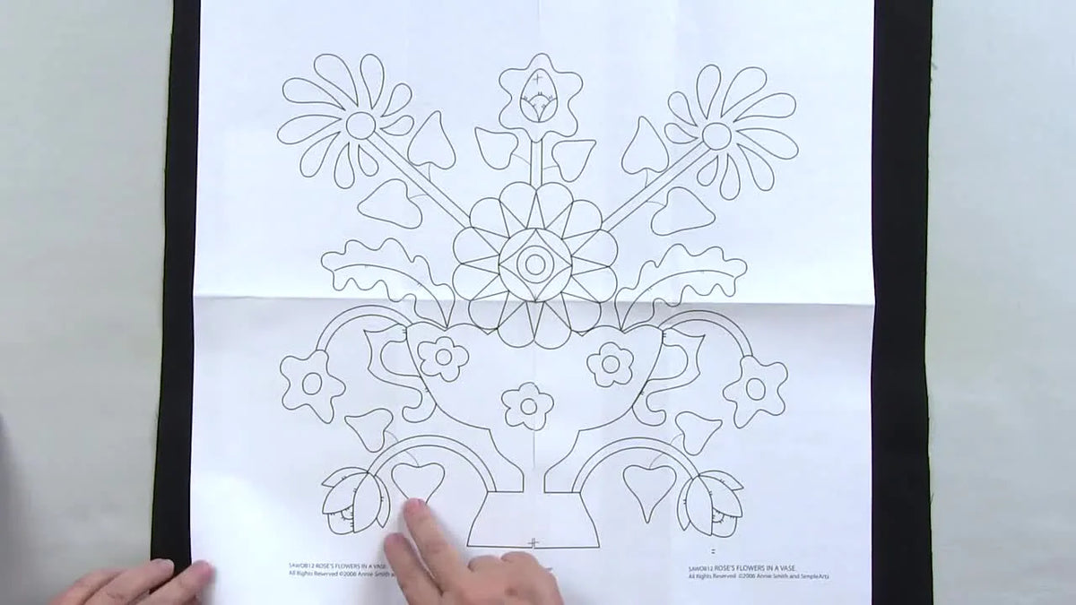 Hands using a tracing wheel over Chacopy paper on black fabric.