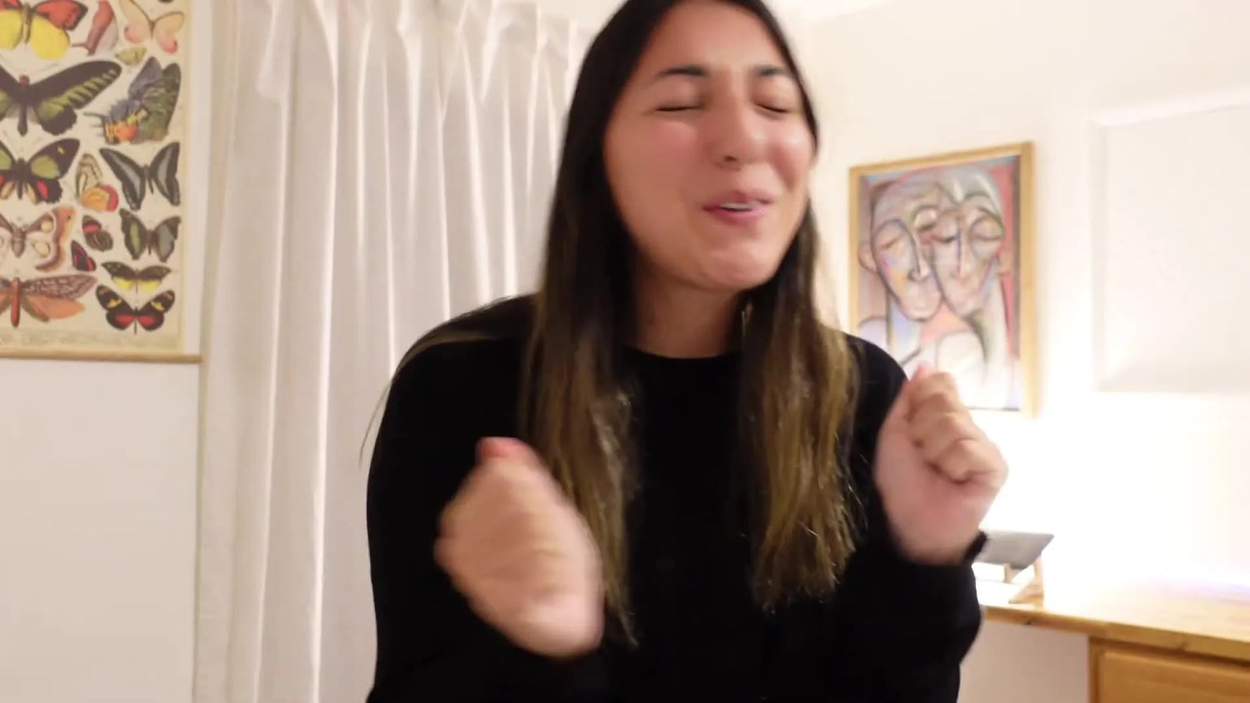 The creator proudly holding up the finished tiny floral baby dress.