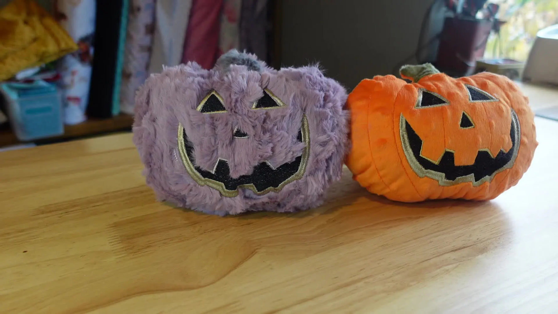 Two finished stuffed pumpkins, one orange and one purple, side by side.