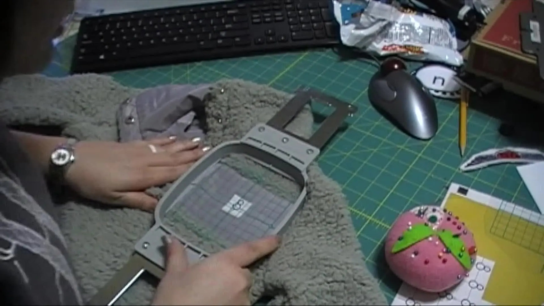 A close-up shows a clear grid template aligning a 4x4 magnetic hoop over thick Sherpa with a Snowman positioning sticker centered for camera scanning.