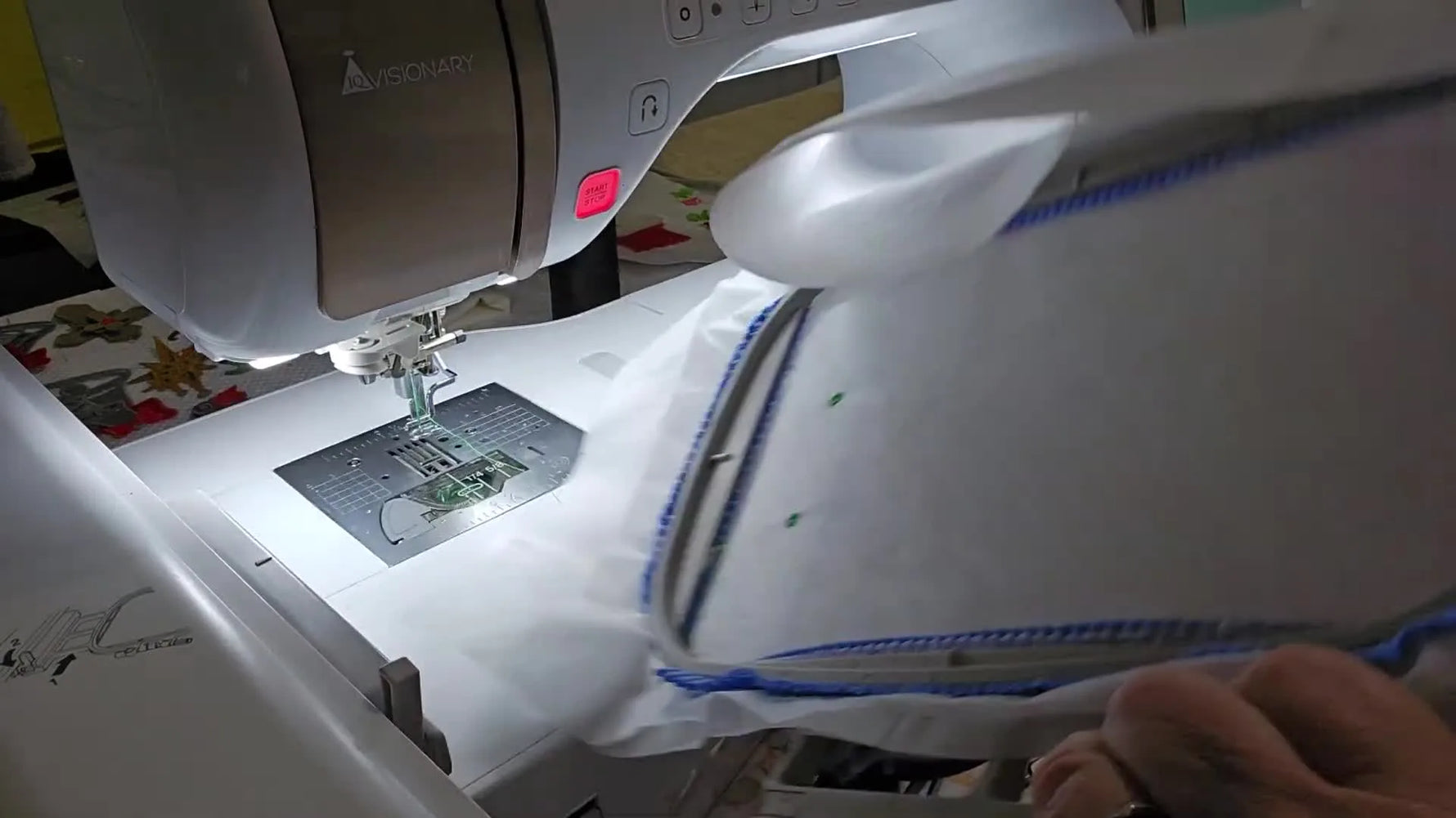 A magnetic embroidery hoop is opened to access the back of water-soluble stabilizer so thread tails can be trimmed before they get stitched into the ITH bow earrings.