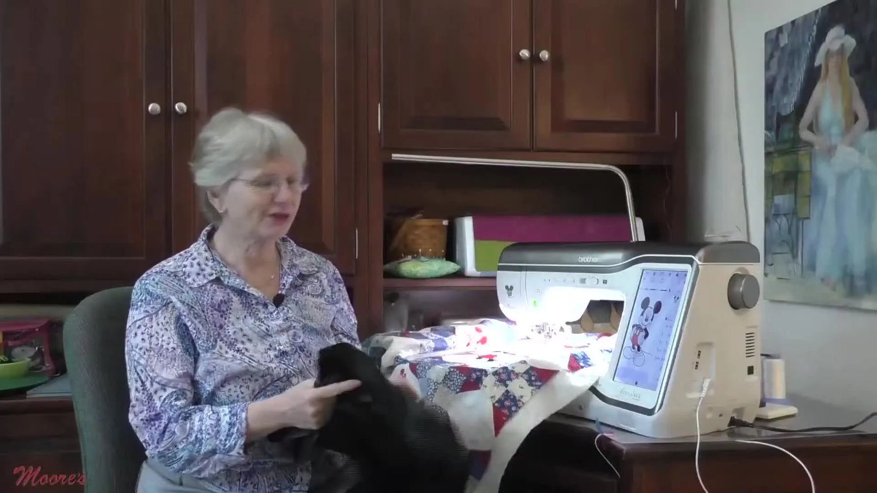 Cathy holds a sheet of black embroidery topper and explains how it improves coverage on high-contrast stitching like Mickey’s ears.