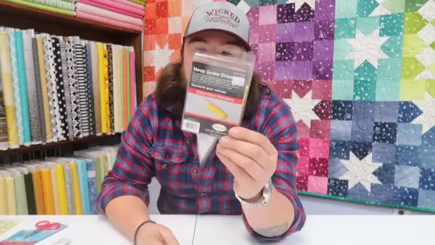 Jordan holds the Baby Lock hoop screwdriver packaging, highlighting a simple tool that prevents loose hoops and ruined stitch-outs.