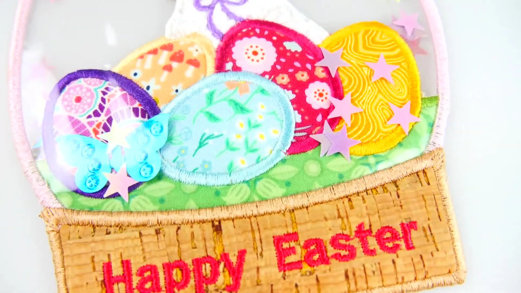 A finished Easter Egg Globe ornament with a bunny, layered applique eggs, and sequins sealed inside a clear PVC shaker window.