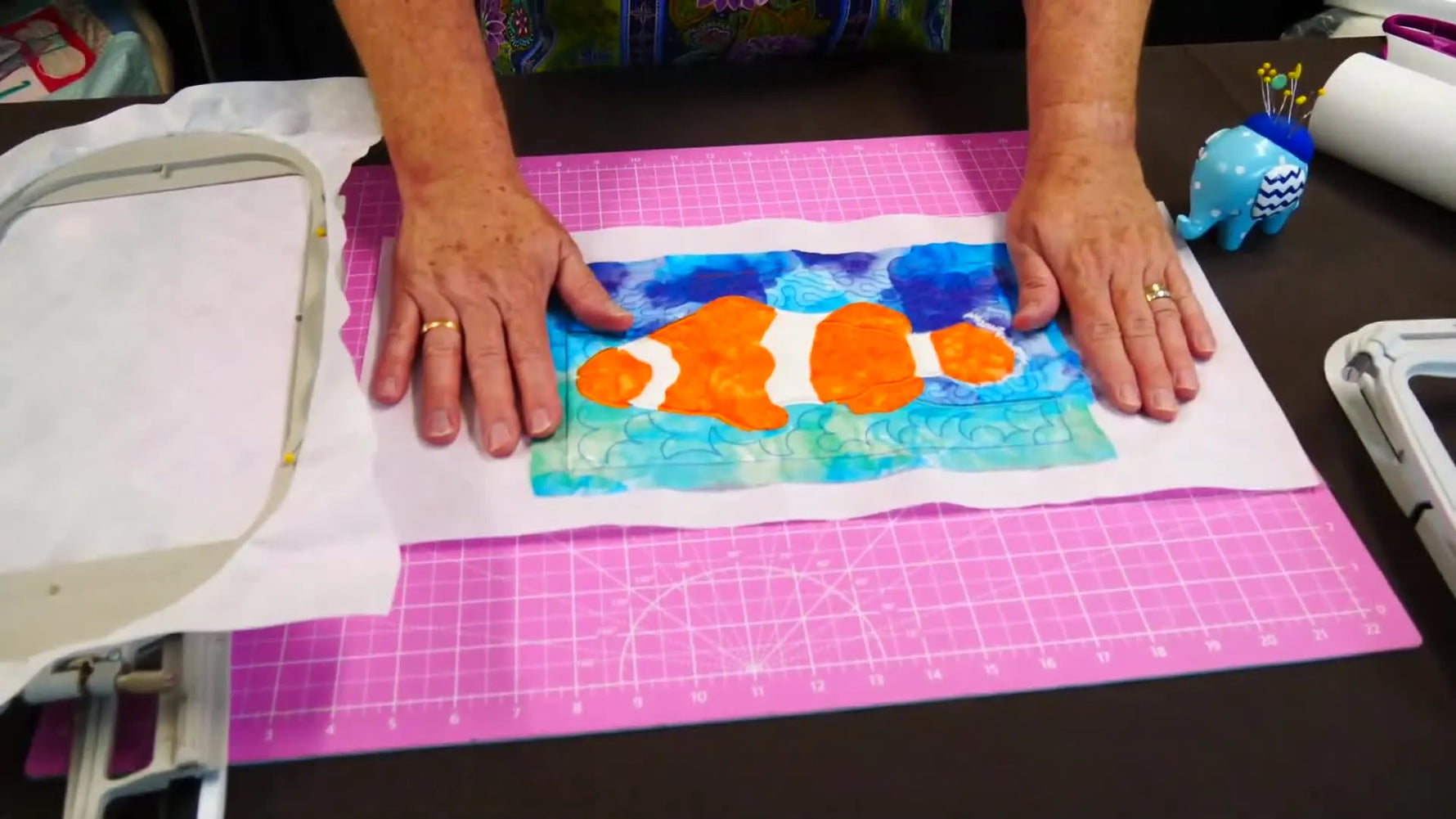 A finished clownfish applique sample lying perfectly flat, showing what correct stabilizer tension looks like after unhooping.