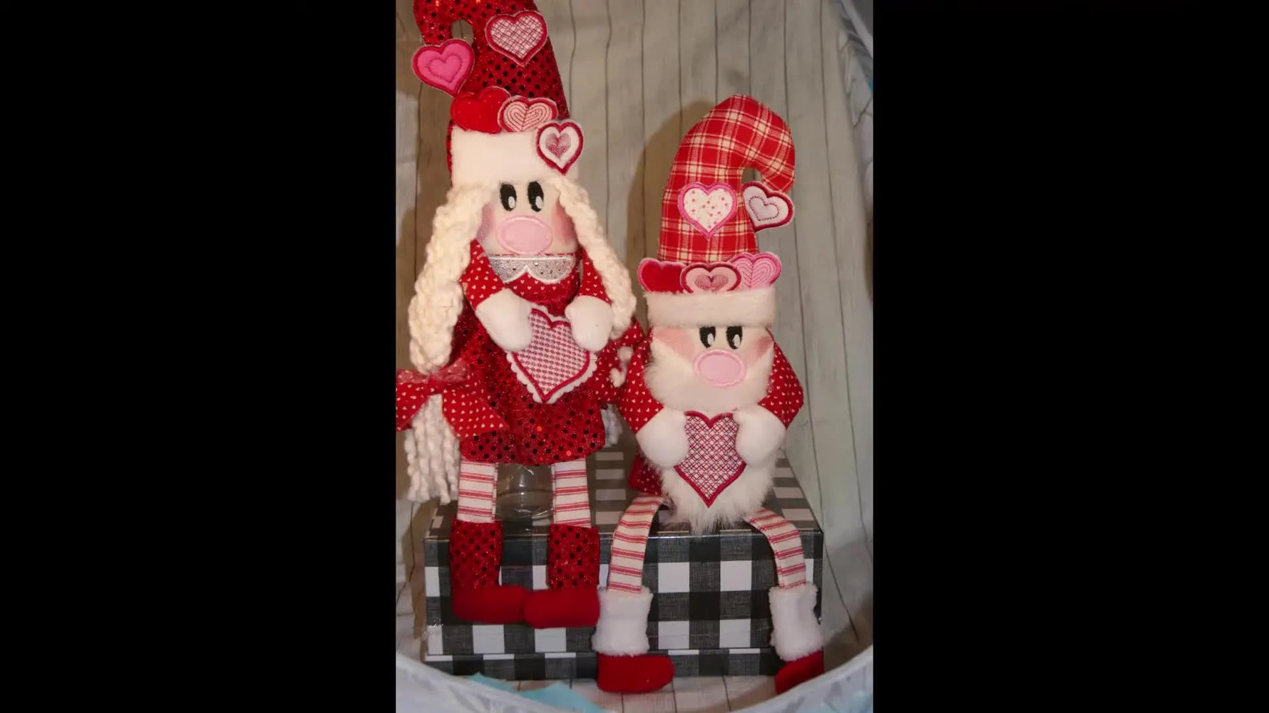 Two finished in-the-hoop Valentine gnomes displayed together, showing the yarn beard texture, stitched legs, and hat details.