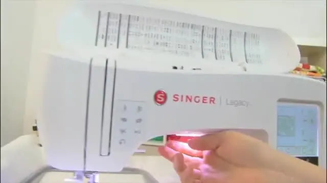 A close-up of lowering the presser foot on a SINGER® Legacy™ right before starting an embroidery stitch-out.