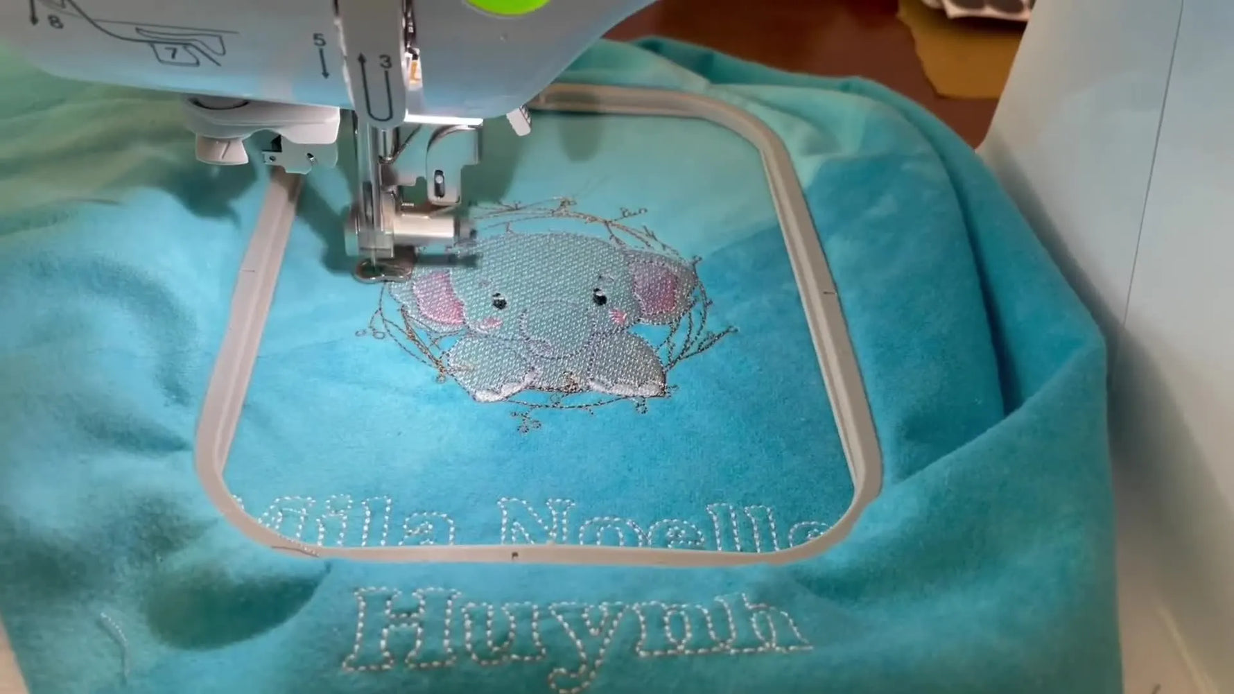 A top-down view of the completed elephant embroidery inside the hoop, ready for inspection before final blanket assembly.