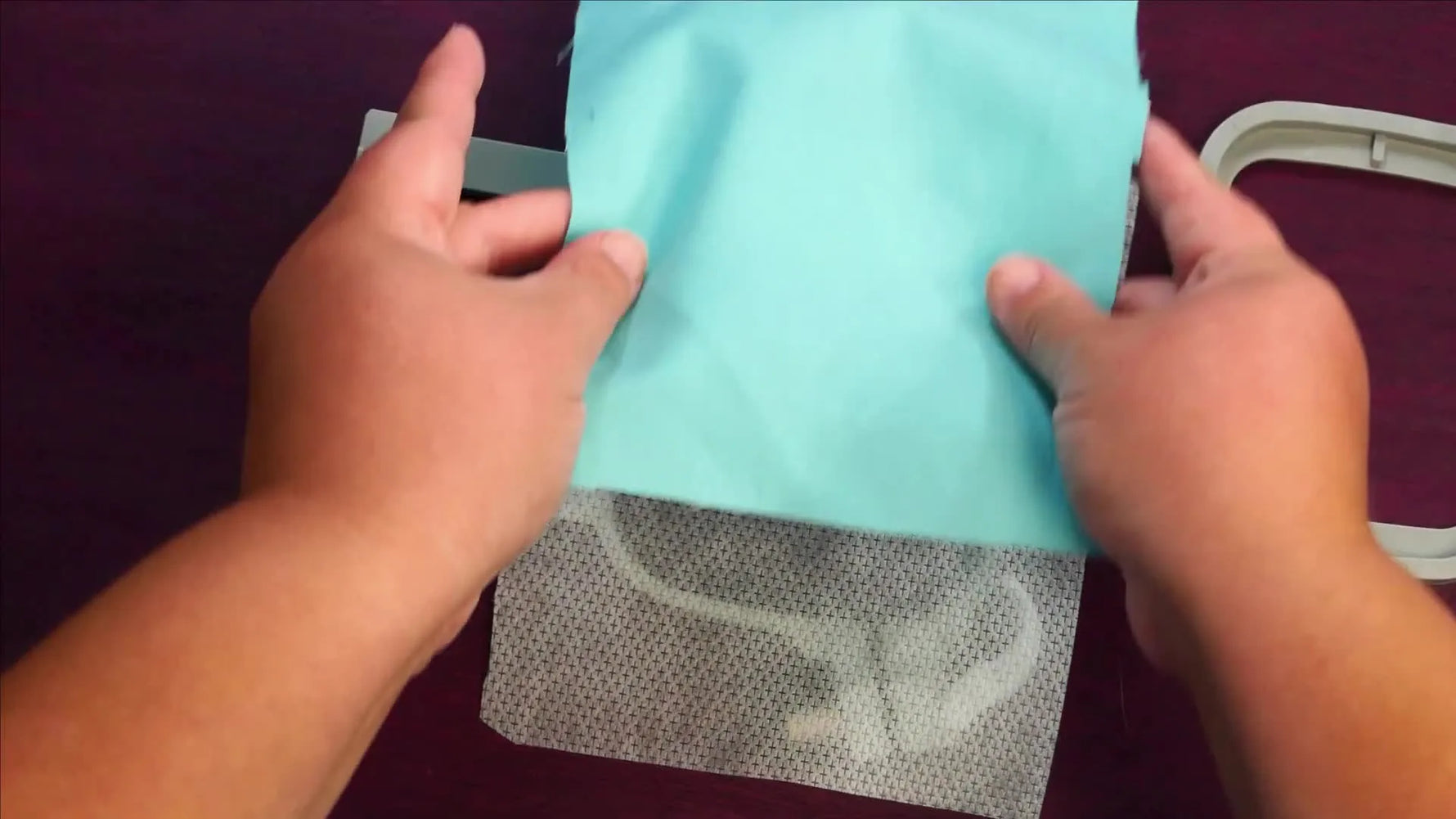 Fabric and no-show mesh stabilizer are layered on the outer hoop, ready for the inner ring to be pressed in for clean, even tension.