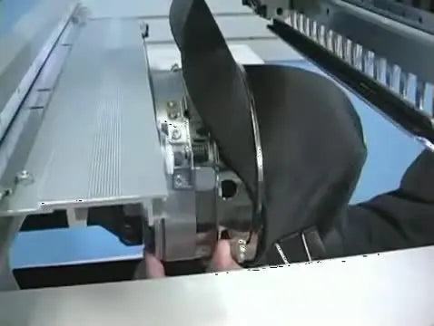 Hands push a hooped cap onto the Toyota cap driver until it snaps into place for sewing.