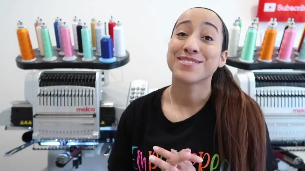 Angela introducing herself beside embroidery machine