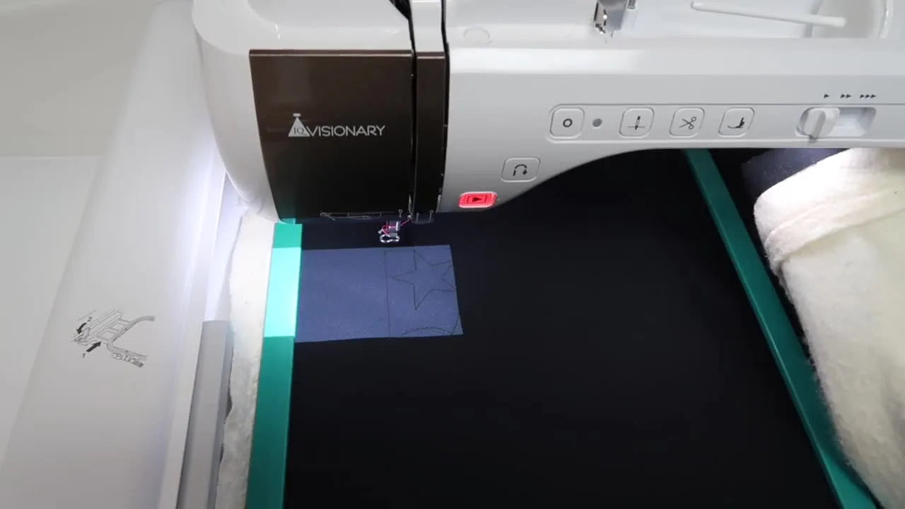 The Solaris Vision projector casts the quilting design box onto black fabric inside a large magnetic hoop for precise edge-to-edge alignment.