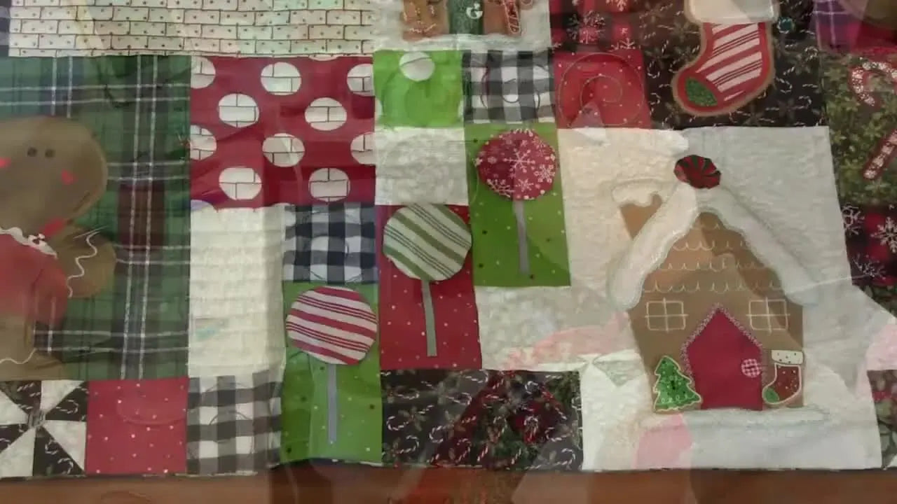 An overhead view of the completed Kimberbell Ginger’s Kitchen bench pillow showing all embroidered blocks and embellishments.