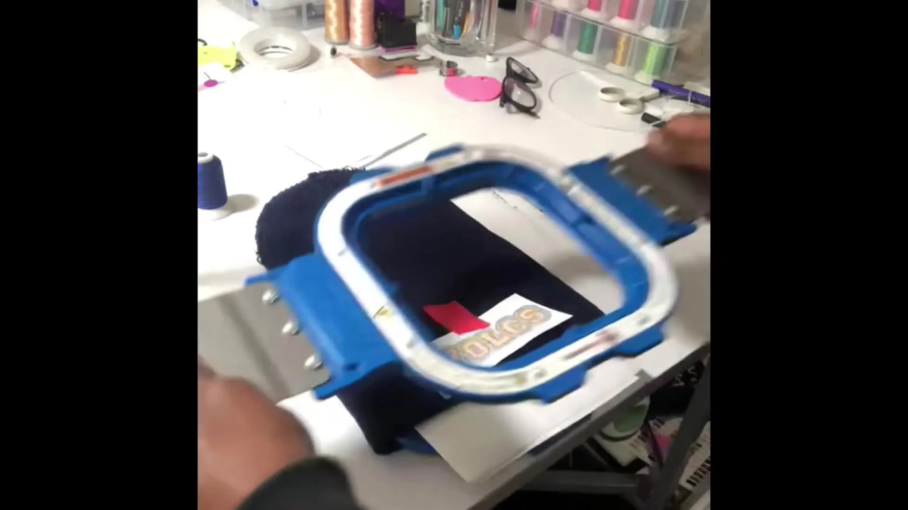 A magnetic hoop snaps onto a thick knit beanie, clamping the fabric evenly for stable stitching without hoop burn.