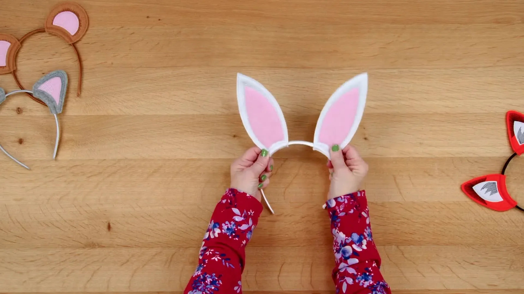 The finished bunny ears headband is displayed flat on a wooden surface, showing crisp edges and upright ears.