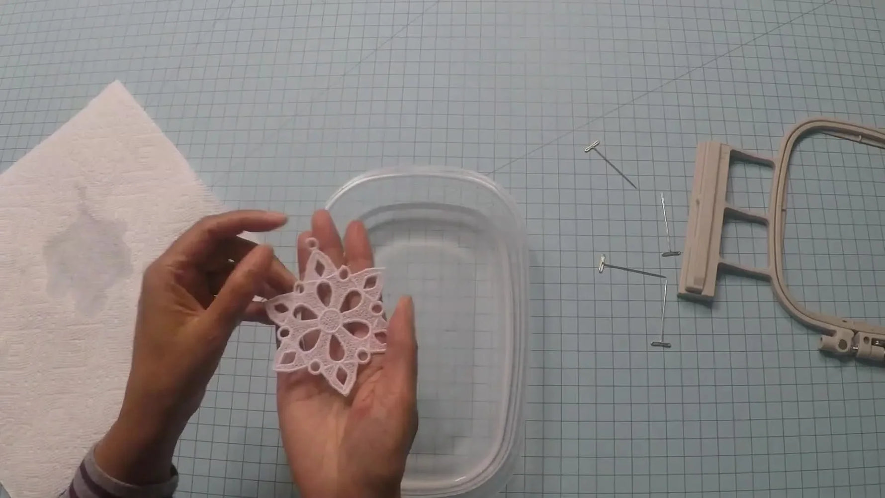 A close-up of the finished wet freestanding lace snowflake resting in a hand right after dissolving the stabilizer.