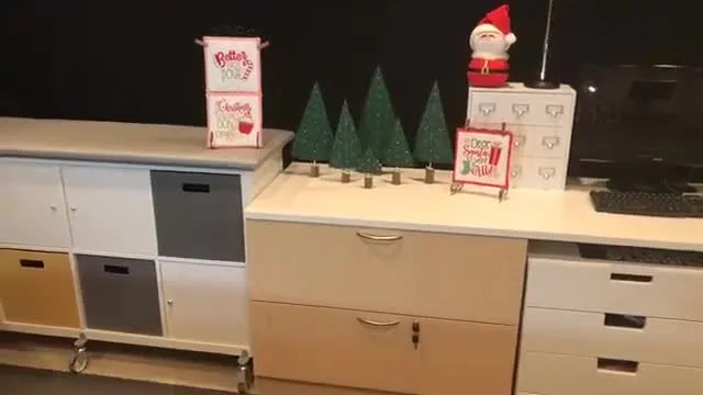 A finished freestanding embroidered holiday tree is shown slightly curved on its stand beside the embroidery machine.