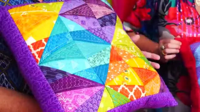 Two bright geometric flip-and-fold cushions are displayed side-by-side to show how color placement changes the final look.