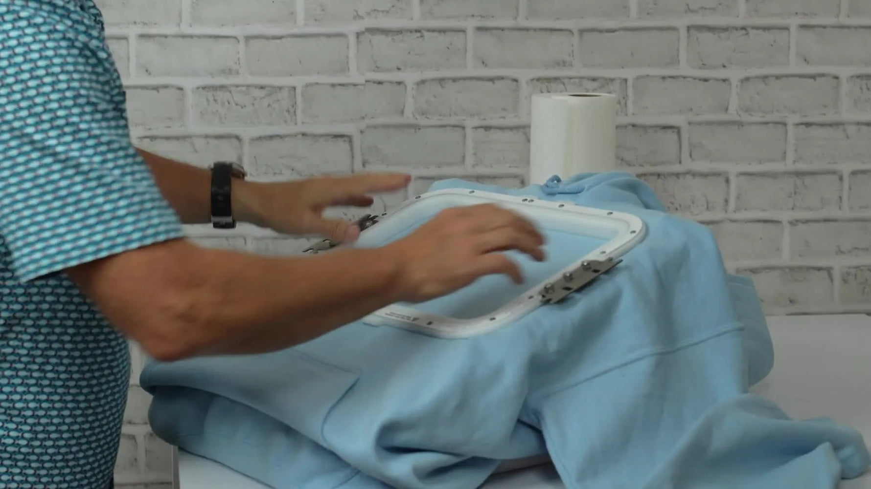 A close-up of a magnetic hoop snapping onto a hoodie, clamping the fabric firmly without stretching.