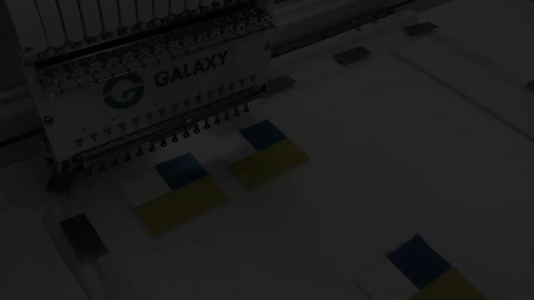 Embroidery machine stitching a quilting design (hearts and bones) on hooped fabric.