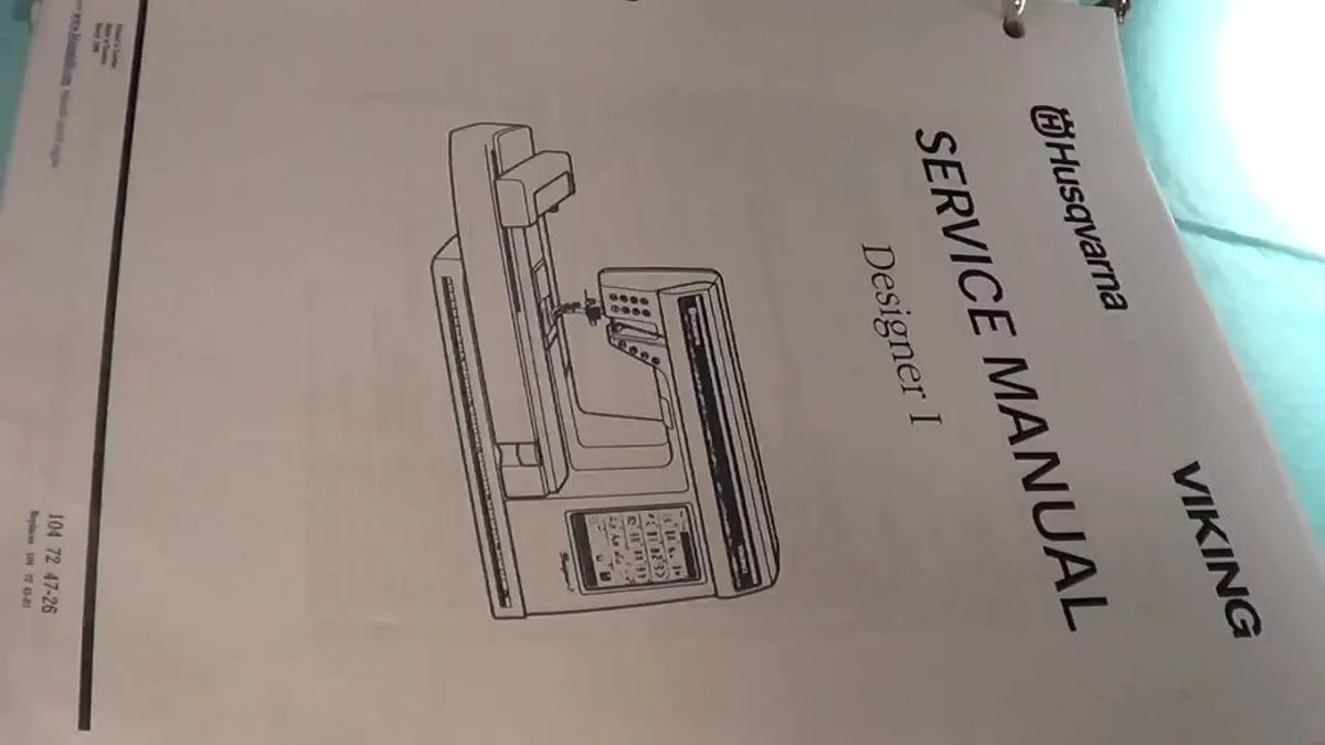 The front cover of the Husqvarna Viking Designer I Service Manual in a binder.