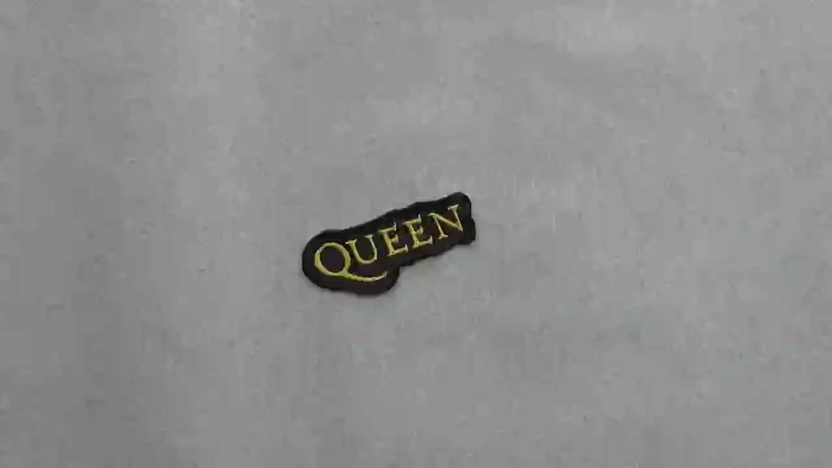 Embroidered 'QUEEN' patch on a light gray background.