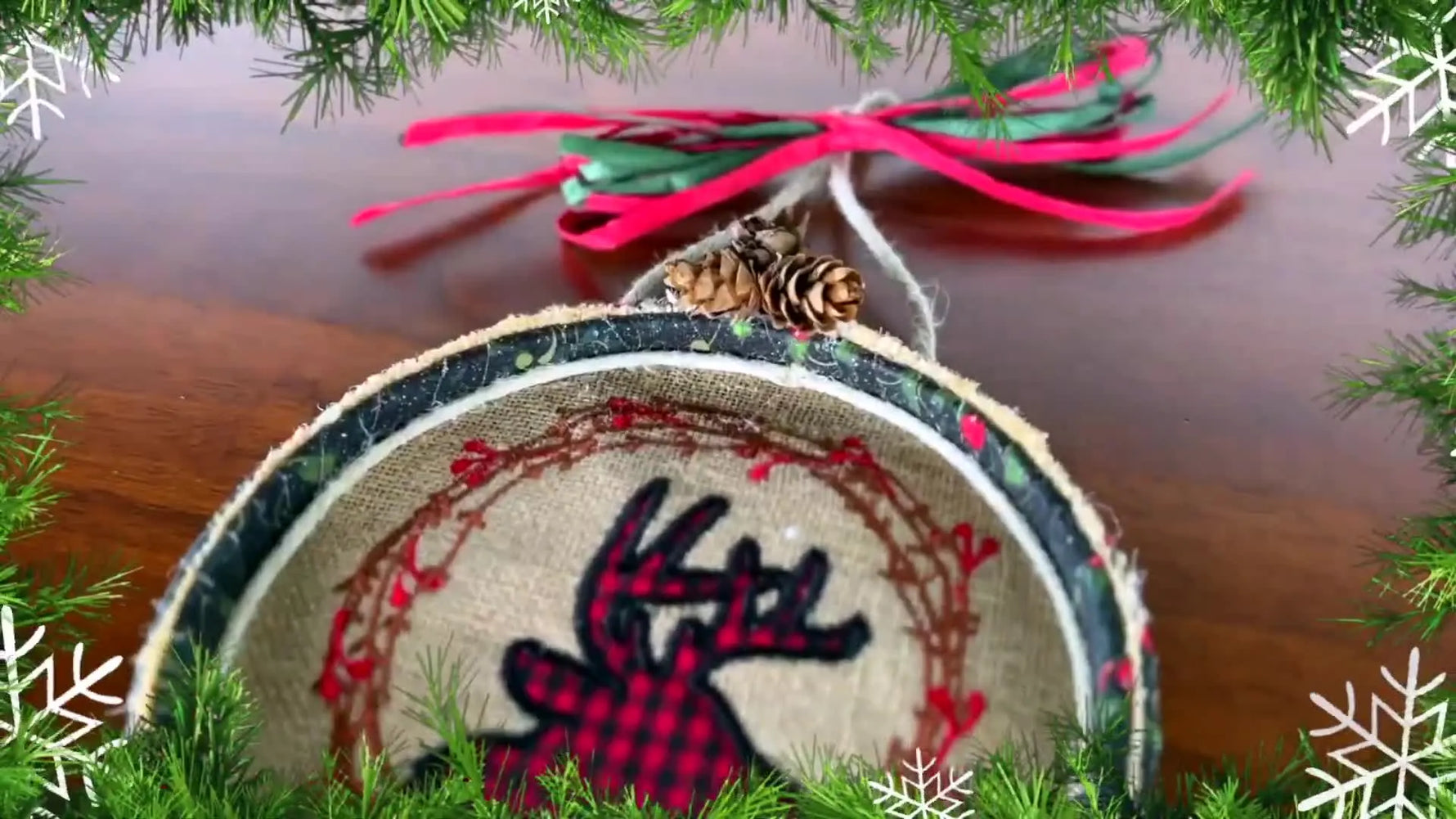 A finished 5x7 deer appliqué hoop wreath hangs neatly with ribbon, showing a clean wrapped hoop and festive embellishments.