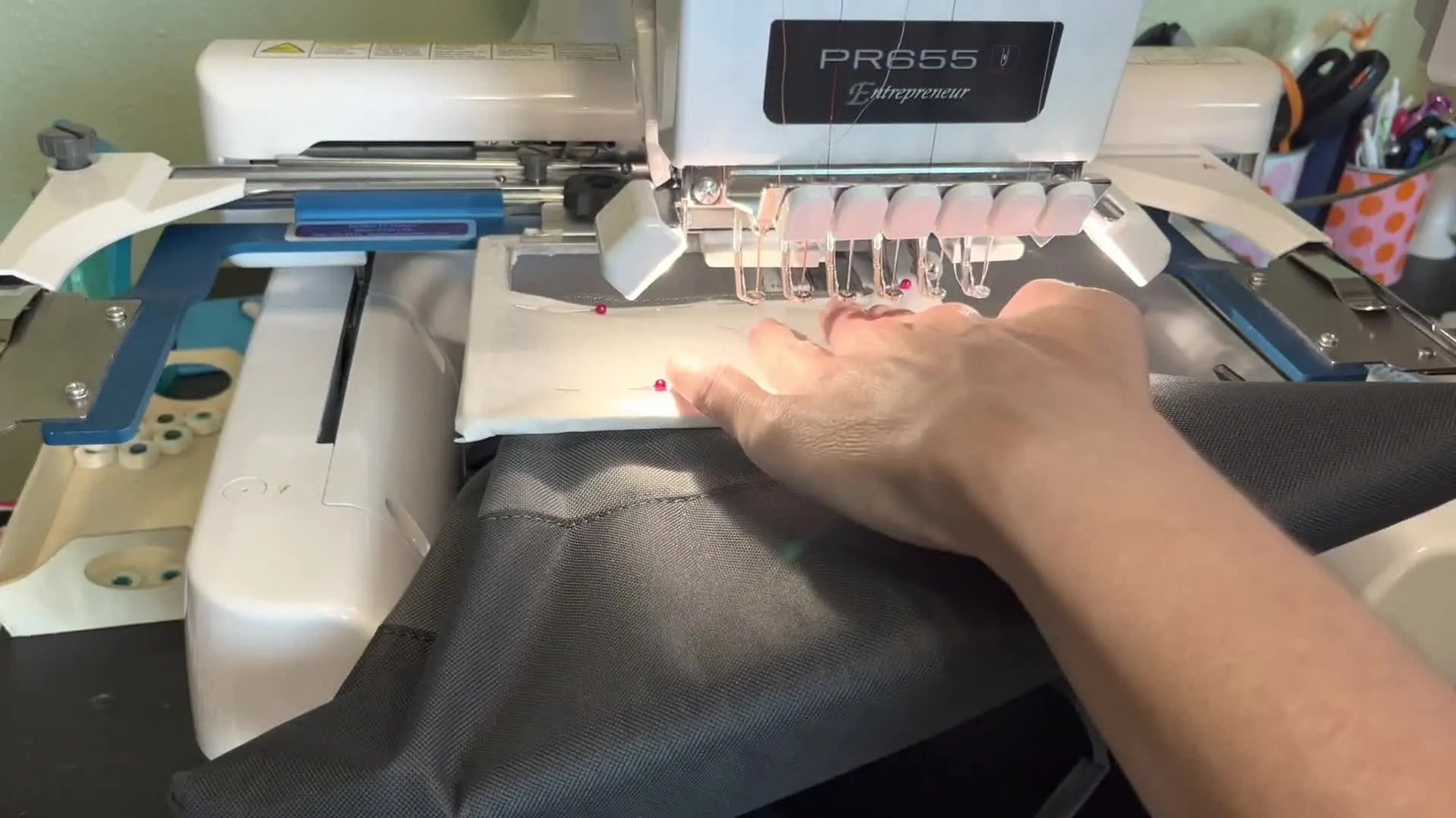 A close-up of the embroidery machine area while checking pocket corner clearance so the bag doesn’t collide with the machine body.