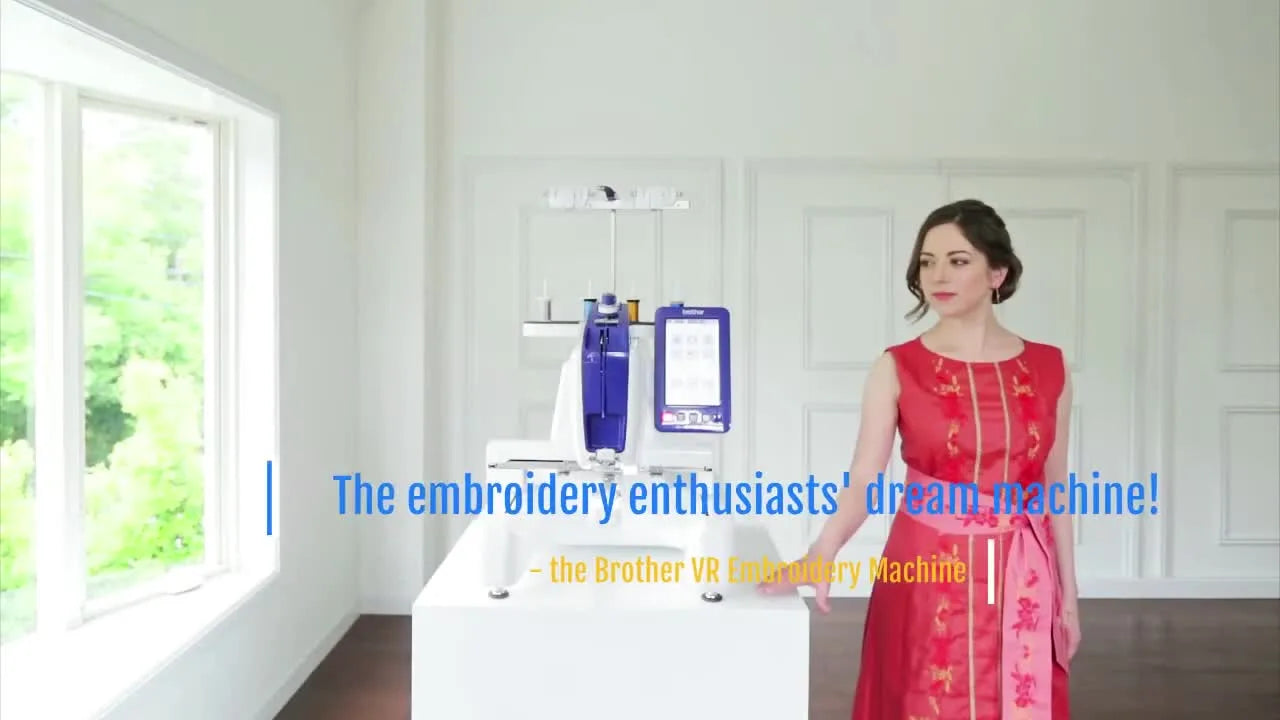 Woman standing beside the Brother VR embroidery machine, looking thoughtfully at it.