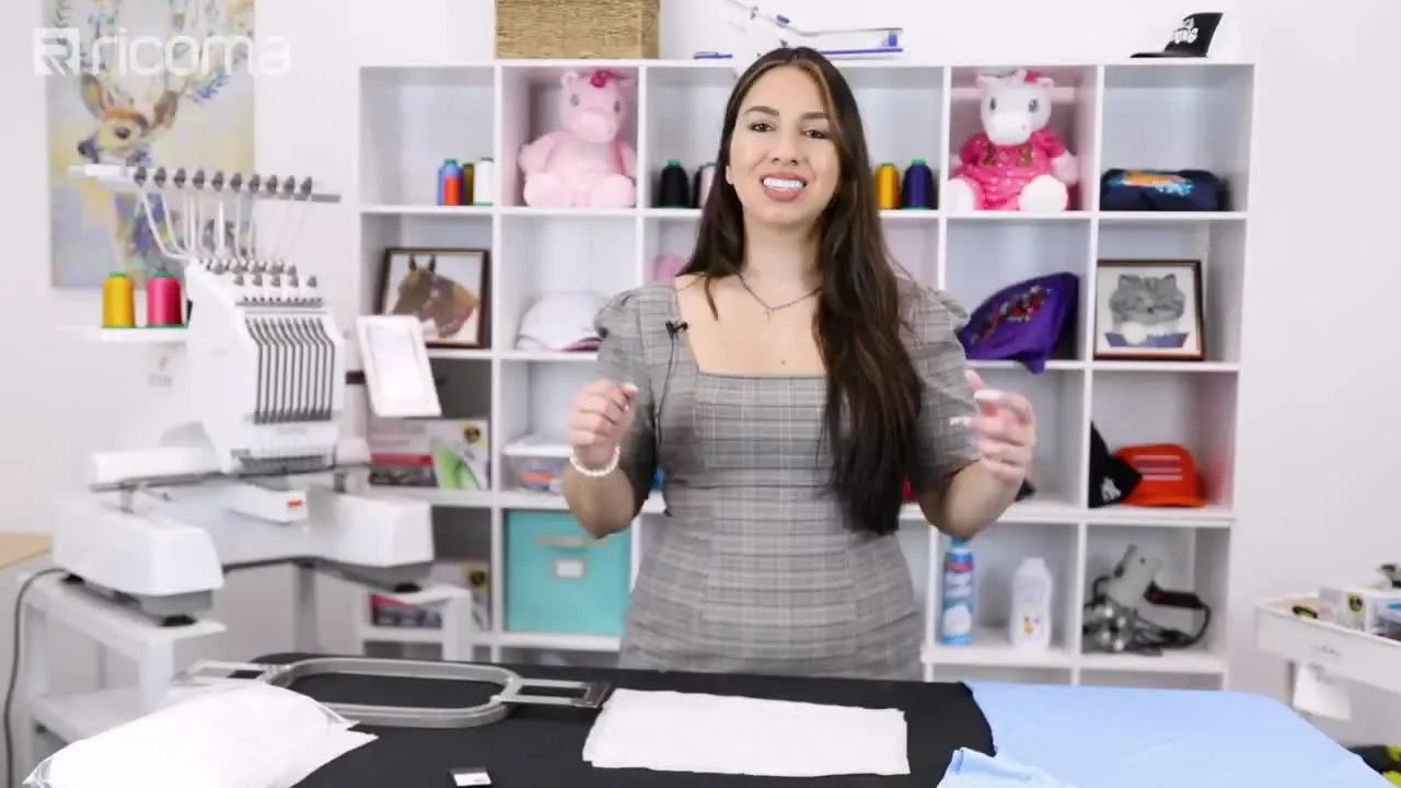 Woman standing in front of an embroidery machine presenting materials for embroidering stretchy fabric.